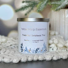 Load image into Gallery viewer, Yellow harp essentials hand poured coconut wax candle with crackling wood wick, and highly scented fresh cut Christmas tree sent. White glass jar with silver metal lid. ￼
