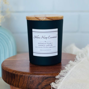 highly scented coconut wax candle with crackling wood wick midnight plum and vintage leather scent black glass reusable jar wooden lid